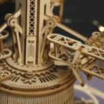 Detailed wooden mechanical clock with gears and moving parts, showcasing craftsmanship and engineering.