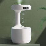 Contemporary white humidifier with a digital clock display, placed on a green surface against a green wall, demonstrating a sleek and minimalist design.