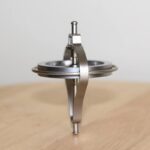 Precision magnetic stirring device with metal components on a wooden surface, used for scientific experiments and educational demonstrations.