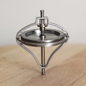 A spinning top toy demonstrating physics principles with a sleek metallic design.