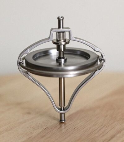 A spinning top toy demonstrating physics principles with a sleek metallic design.