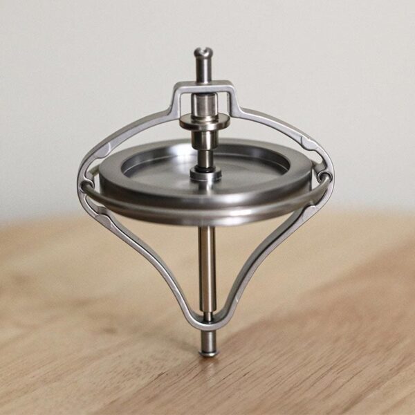 A spinning top toy demonstrating physics principles with a sleek metallic design.
