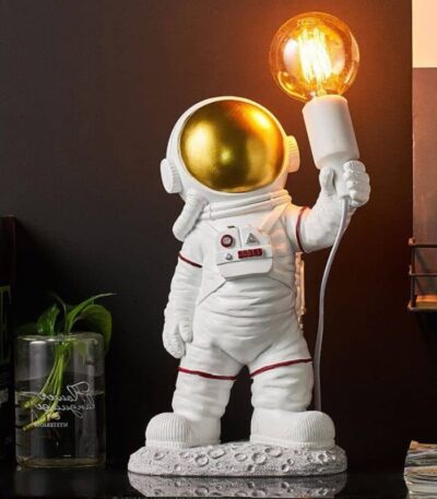 Cute astronaut figurine holding a glowing light bulb, perfect as a decorative piece or educational toy for space enthusiasts.