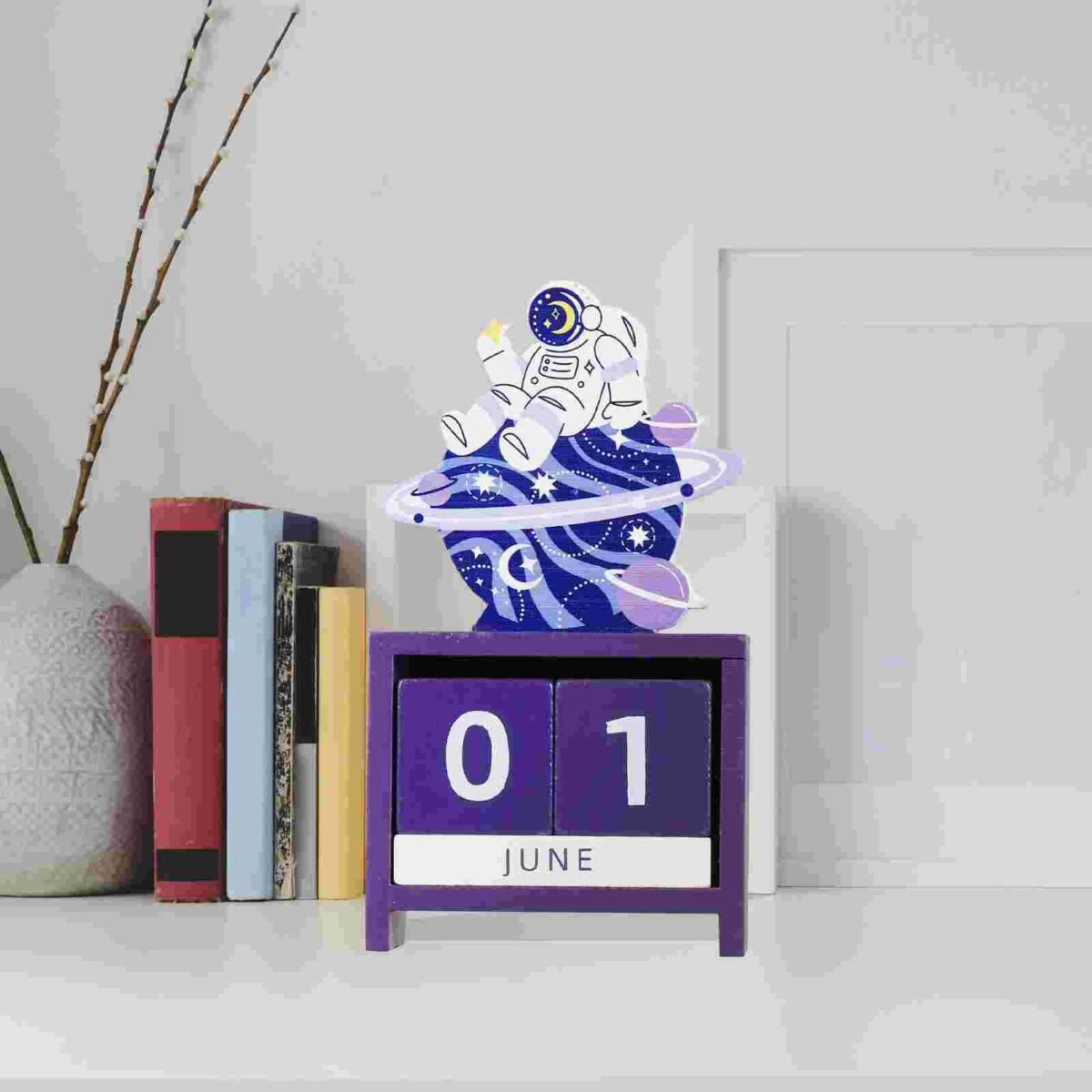 Decorative space-themed desk calendar featuring an astronaut, planets, and swirling galaxy design, perfect for science enthusiasts and educational decor.
