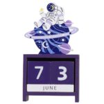 Space-themed astronaut desk calendar featuring a whimsical astronaut figure sitting on a celestial globe with planets and stars, perfect for science enthusiasts and educational decor.