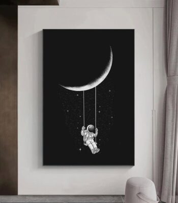 Artistic black and white wall art featuring a crescent moon and an astronaut hanging from a string, perfect for space enthusiasts and modern interior decor.