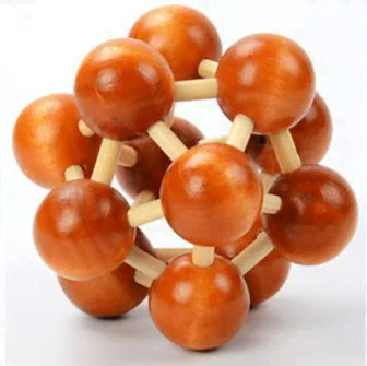 A detailed molecular model with orange and beige plastic balls representing atoms and bonds, used for teaching chemistry concepts.