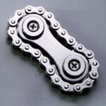 Close-up of a metallic bike chain link with detailed sprockets, showcasing mechanical precision and engineering design.