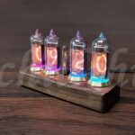 Vintage Nixie tube clock with colorful glowing digits on a wooden base.
