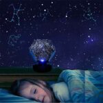 Child sleeping under a star projector night light displaying constellations and star patterns on the ceiling, creating a calming bedtime environment.