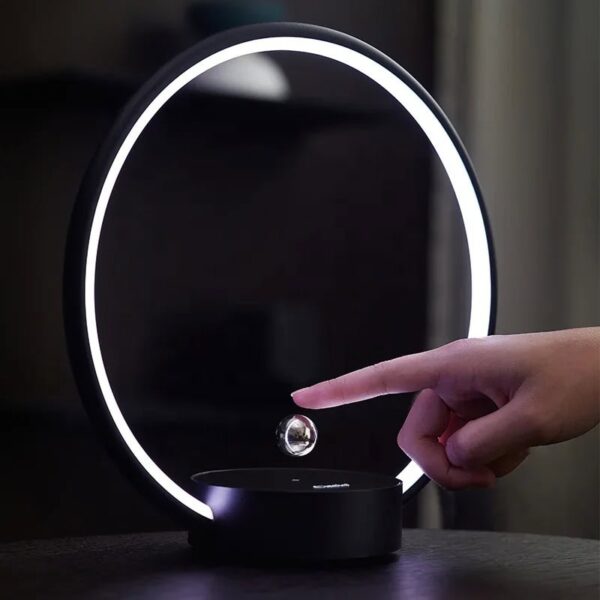 Modern magnetic levitation desk lamp with a glowing ring and floating sphere, demonstrating innovative science decor and educational technology.