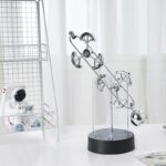 Modern kinetic sculpture with metal balls and gears for science decor and educational purposes.