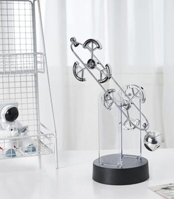 Modern kinetic sculpture with metal balls and gears for science decor and educational purposes.