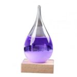 Colorful liquid-filled glass dropper with purple liquid on wooden base.