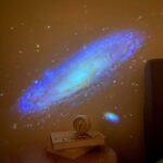 Galaxy projector displaying a vibrant, blue and white spiral galaxy on the wall.