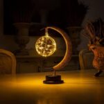 A decorative lamp featuring a glowing globe and crescent moon, creating a celestial ambiance. Perfect for science-themed decor or educational spaces, emitting warm, inviting light.