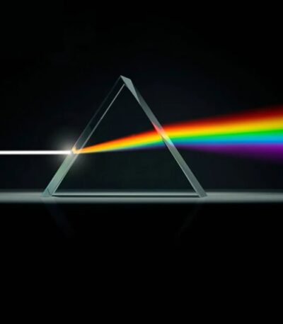 A triangular glass prism dispersing white light into a spectrum of colors, demonstrating light refraction and dispersion principles.