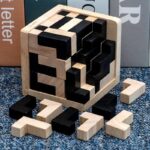 Wooden brain teaser puzzle cube with black and natural wood pieces, ideal for educational toys, brain training, and cognitive development.