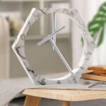 Elegant hexagonal marble clock with minimalist design, featuring a sleek metal hour and minute hand. Perfect for contemporary interiors and adding a touch of sophistication to any space.