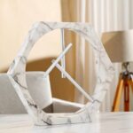 Modern hexagonal marble clock with sleek metallic hands, stylish home decor piece.
