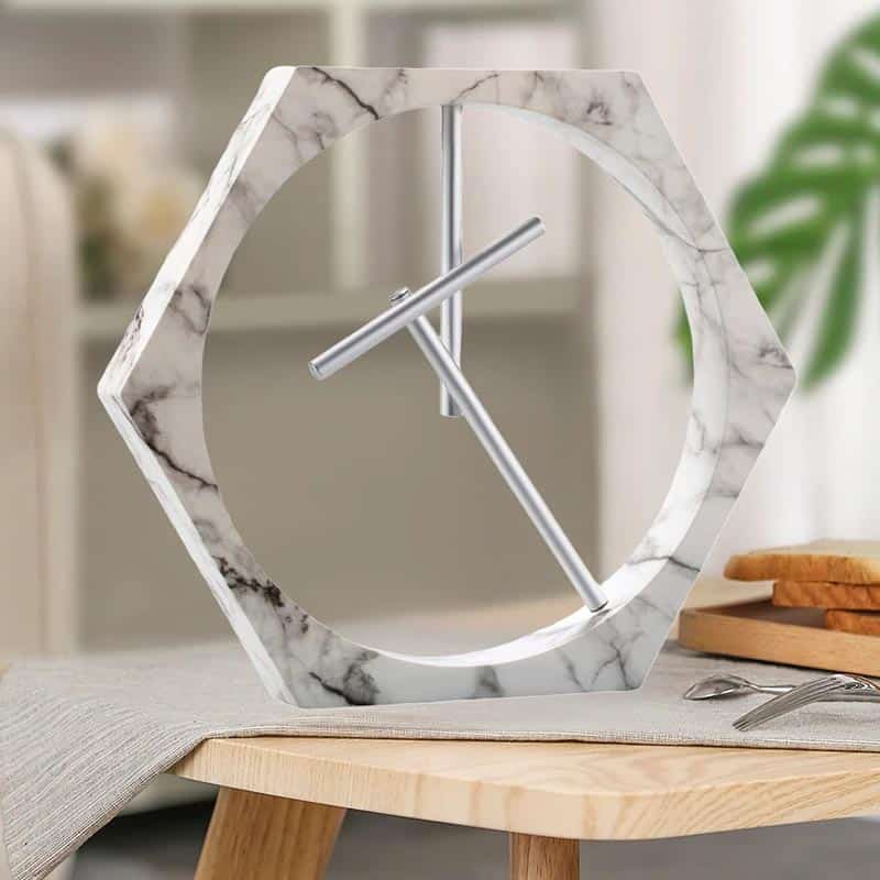 Elegant hexagonal marble clock with minimalist design, featuring a sleek metal hour and minute hand. Perfect for contemporary interiors and adding a touch of sophistication to any space.