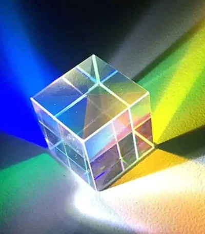 Transparent glass cube projecting vibrant rainbow colors through light refraction, ideal for science-themed decor and educational displays.