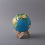 Earth globe model showing continents and oceans, mounted on a wooden stand, ideal for educational purposes and science decor.