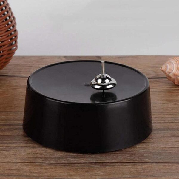 A magnetic pendulum science toy with a black circular base and a metal pendulum, designed for educational and decorative purposes.