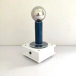 A vintage-style electrostatic generator with a shiny metal sphere on top, mounted on a blue and white base, used for demonstrating static electricity in science experiments.