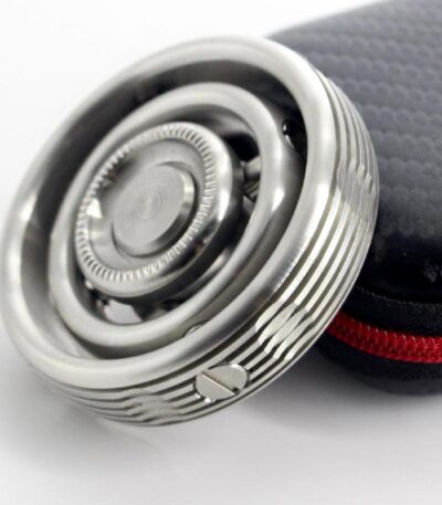 Close-up of a modern safety razor with a textured handle, placed next to a black protective case with red zipper, on a white background.
