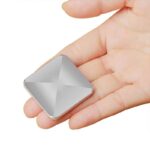 Small silver geometric puzzle piece held in a person's hand, showcasing its shiny, reflective surface and precise angular design.