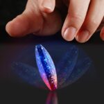 Hand interacts with a holographic crystal butterfly light display, showcasing vibrant blue and pink colors, perfect for science decor and educational purposes.