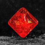 Close-up of a vibrant red gemstone cube with intricate internal reflections, perfect for science-themed decor and educational toy displays.