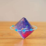 Bright holographic spinning top with iridescent surface and rotating arrows illustration.