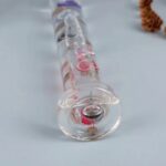 Transparent glass pendulum with colorful magnetic liquid inside, demonstrating magnetic and fluid dynamics for educational purposes.