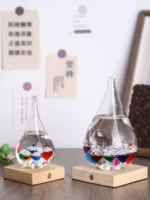 Colorful chemical reaction glassware with liquid and small objects inside, displayed on wooden bases.
