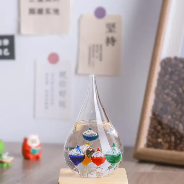 Colorful liquid-filled glass dropper with floating orbs on a wooden base, used for science experiments and educational demonstrations.