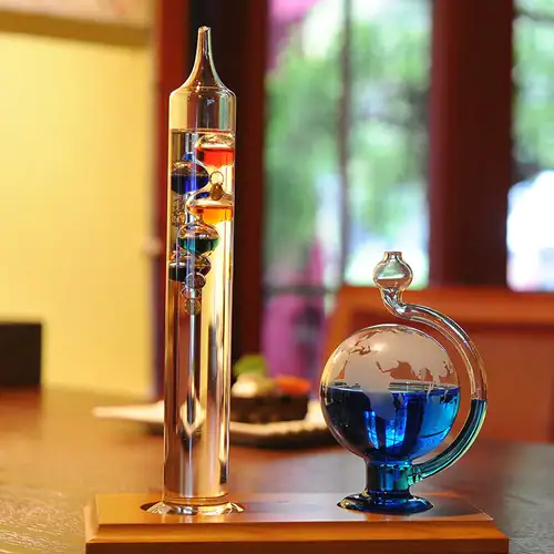 Glass containers with colorful magnetic fluids and metal balls, showcasing a science experiment on magnetism and fluid dynamics.