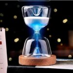 Sand timer with blue liquid in glass, featuring a wooden base, used for measuring time in science experiments and educational activities.