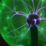 Close-up of a Tesla coil generating vibrant purple and green electrical sparks against a dark background, showcasing high-voltage electrical phenomena.