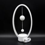 Modern magnetic levitation science toy with a circular frame and suspended spheres demonstrating magnetic repulsion. Includes power cable for educational and decorative use.