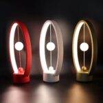 Three illuminated magnetic levitation pendulums in red, white, and gold, showcasing modern science decor with glowing orbs and sleek design.