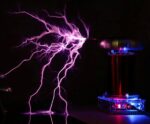 Close-up of a Tesla coil producing vivid purple lightning bolts in a dark environment, showcasing electrical science in action.