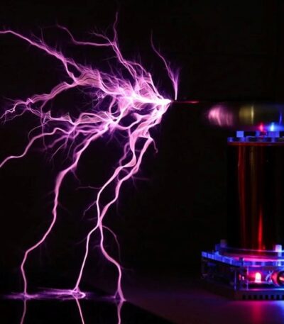 Close-up of a Tesla coil producing vivid purple lightning bolts in a dark environment, showcasing electrical science in action.