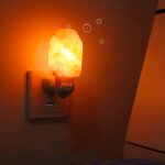 Salt lamp with bubbles effect emitting a warm, soothing glow on the wall.