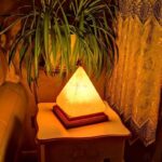 Salt lamp with pyramid shape emitting warm amber glow.
