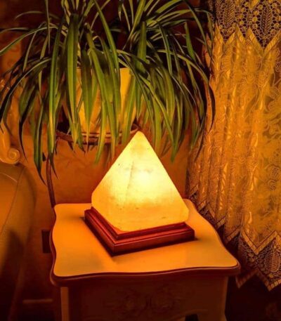 Salt lamp with pyramid shape emitting warm amber glow.
