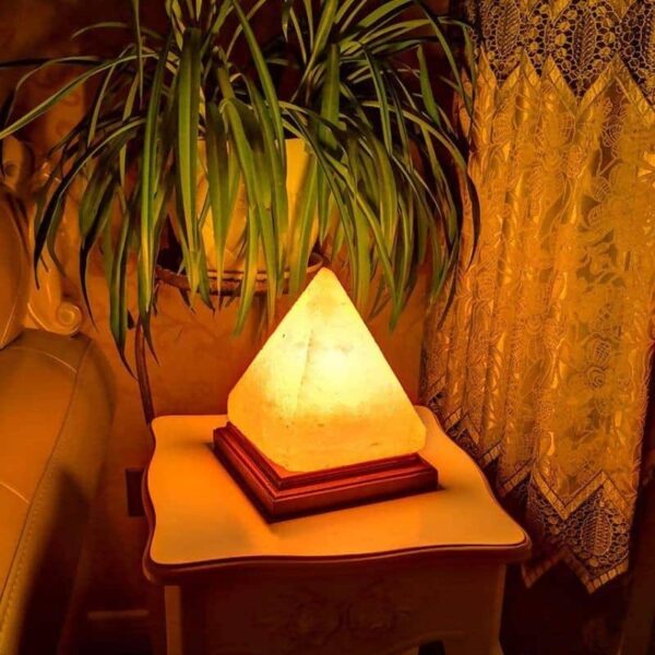 Salt lamp with pyramid shape emitting warm amber glow.