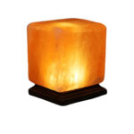 Himalayan salt lamp on a wooden base emitting warm, ambient light, ideal for home decor and creating a relaxing atmosphere.