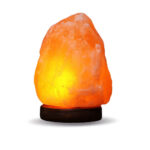 Himalayan salt lamp emitting warm orange glow on a black wooden base, ideal for home decor and creating a relaxing atmosphere.